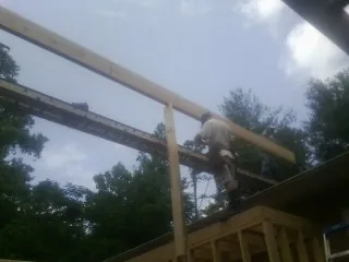 Carpenter setting a ridge beam over a new addition frame — Ice Dam Removal by Roofing Brothers in Silver Lake